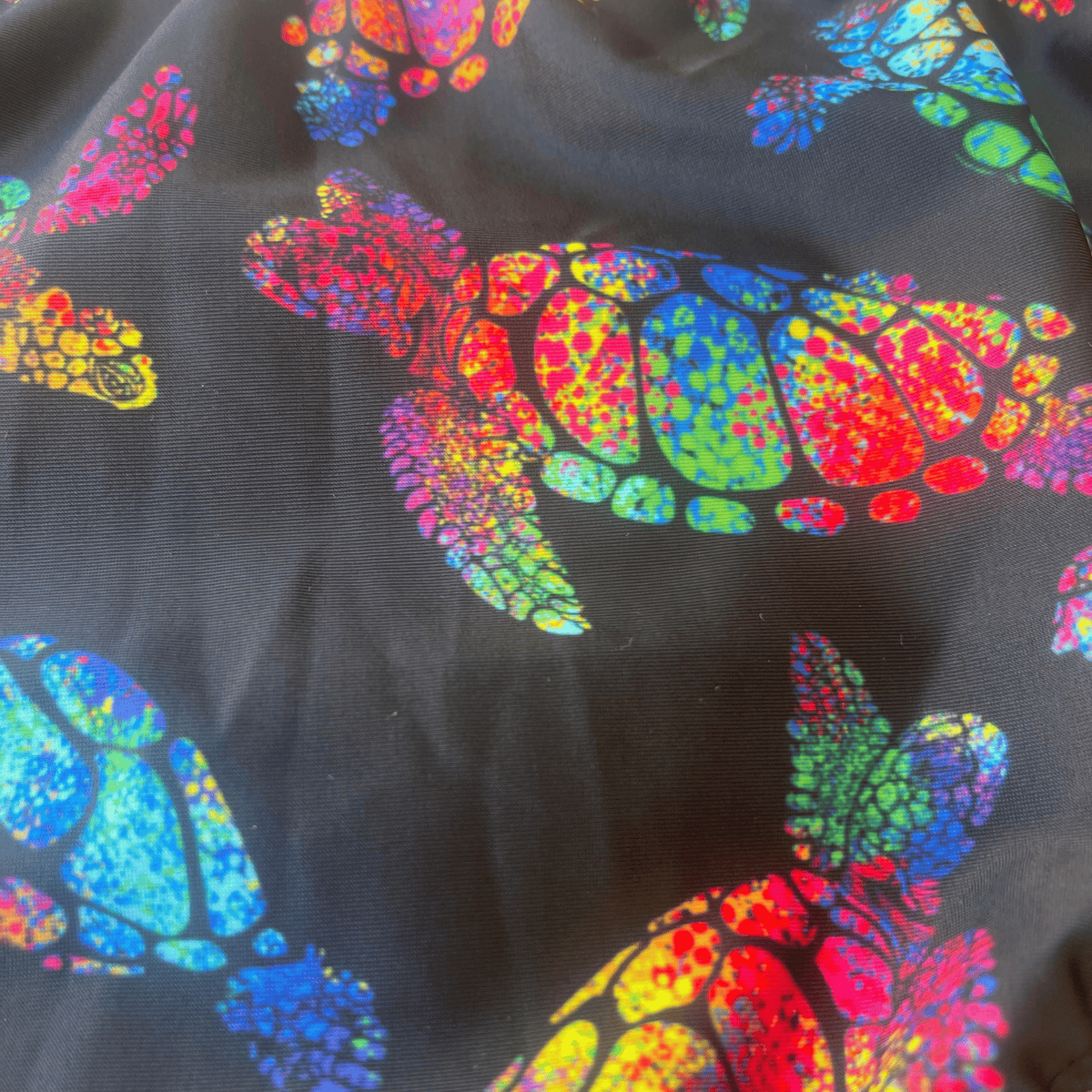 Kikx Extra Life Thin Strap Swimsuit in Larger Turtle Tango Print on Black Background with Neon Yellow Straps