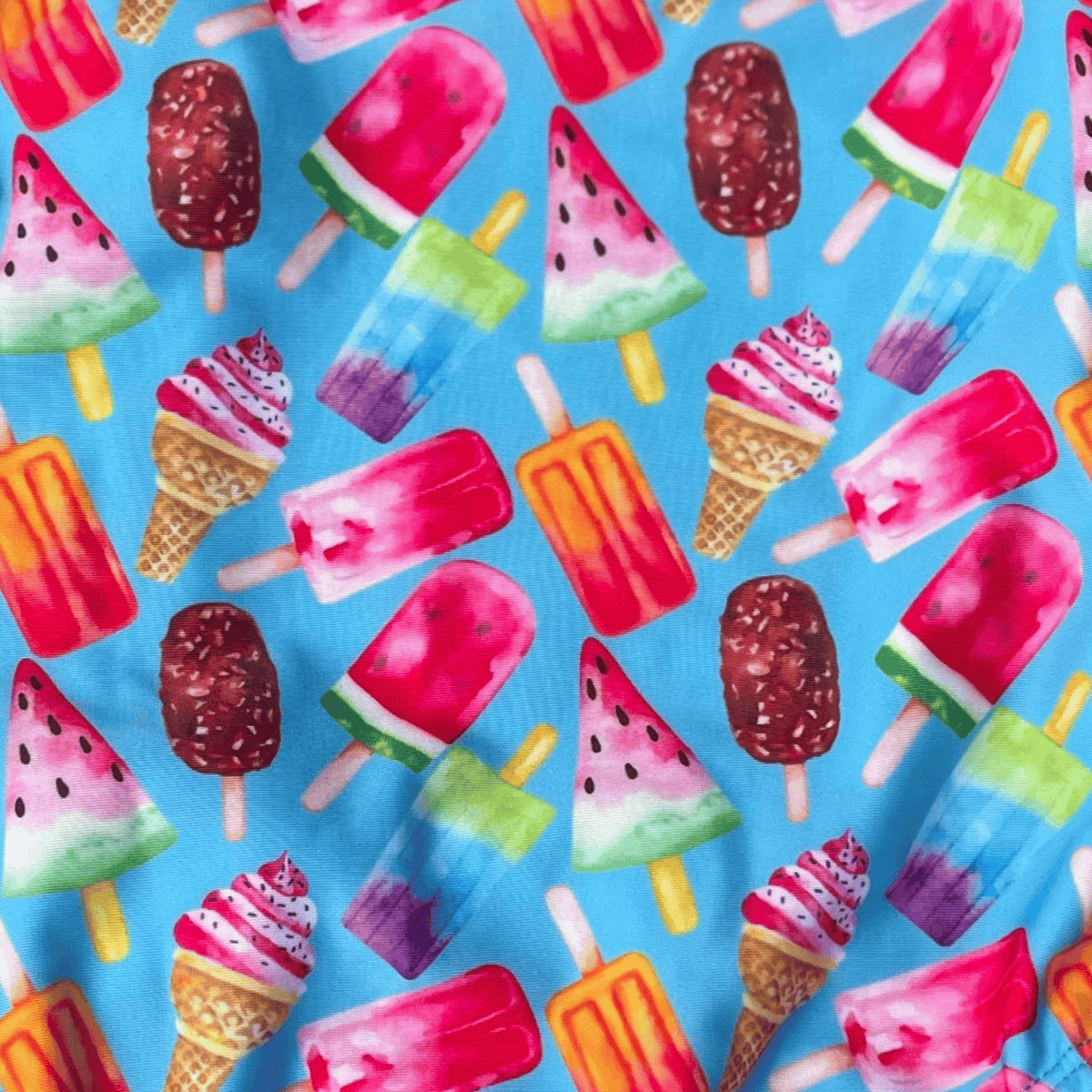 Kikx Extra Life Fastback Swimsuit in Fruity Frostbite Design on Light Blue Background